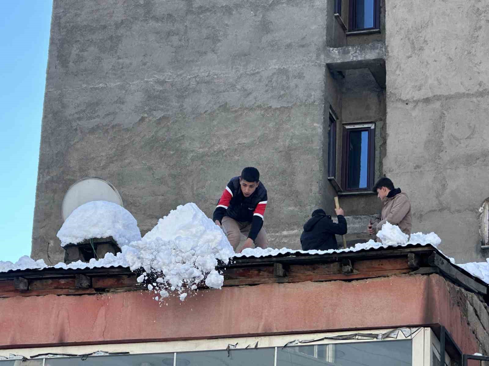 Vatandaşlar çatıdaki kar kütlelerini brandayla indirdi